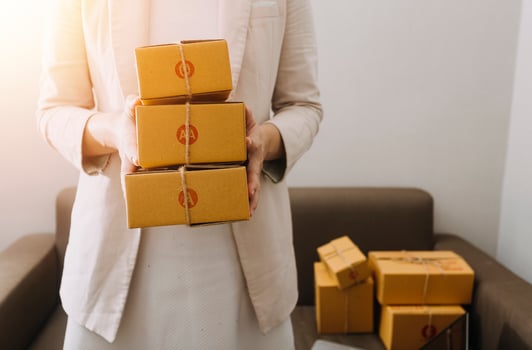 Startup SME small business entrepreneur of freelance Asian woman using a laptop with box Cheerful success Asian woman her hand lifts up online marketing packaging box and delivery SME idea concept photo
