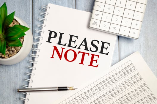 please note word on notepad with glasses and chart photo