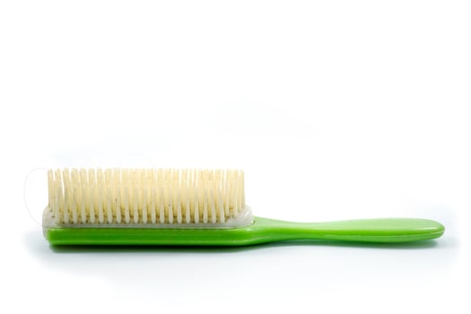 A used green hair comb has hair residue attached photo