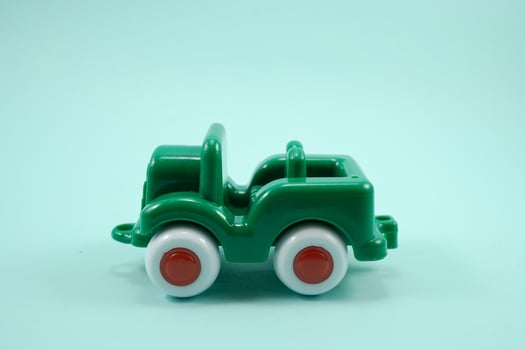Army car open roof green paint plastic toy isolated on turquoise photo