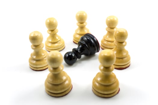 a group of white chess pawns make a circle in the middle there is a black photo