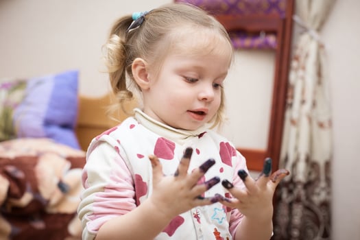 little Caucasian girl with hands in paint after drawing. photo