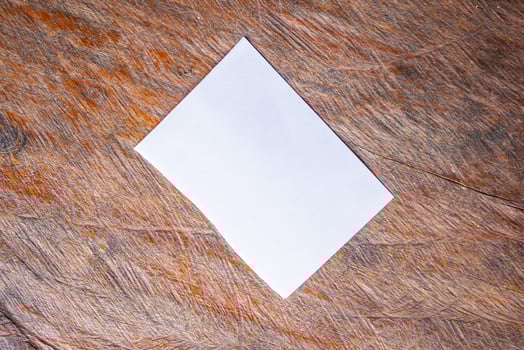 Blank white paper on old rustic wood table background photo