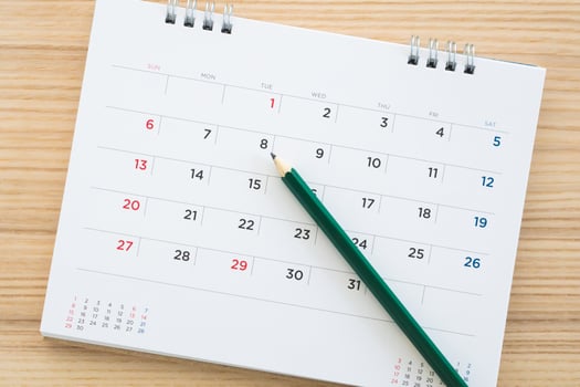 calendar page with pencil on wood table background photo