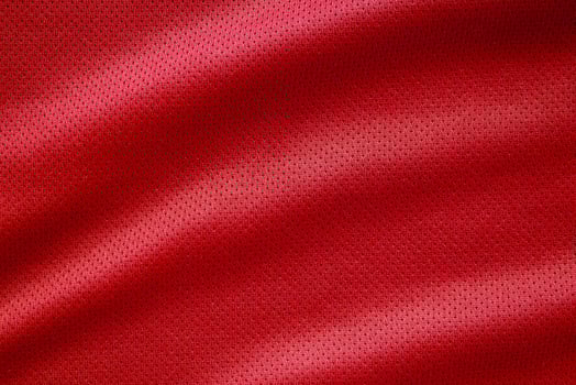 Red fabric sport clothing football jersey with air mesh texture background photo