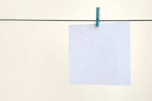 White blank cards on rope, light wall background. Creative reminder, small sheets of paper on old clothespin, memo backdrop photo