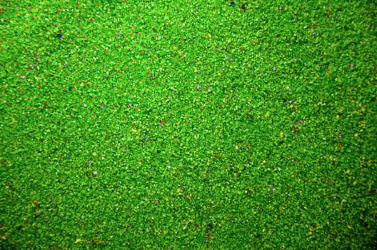 Texture of a colored granular sand close up. Green grains photo