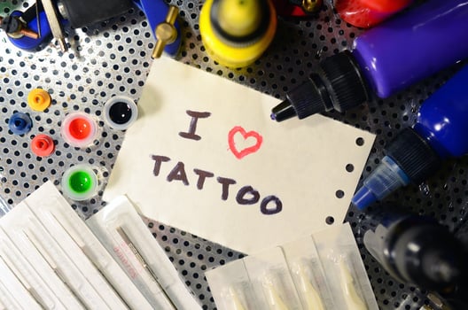 I love tattoo. The text is written on a small sheet of paper among various equipment for tattooing photo