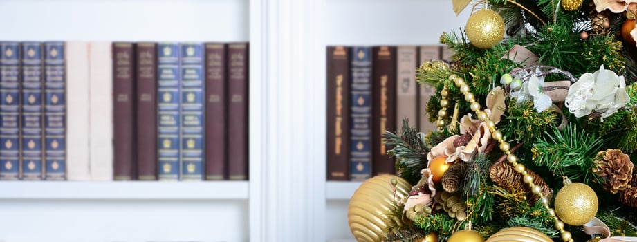 A beautiful decorated Christmas tree on the background of a bookshelf with many books of different colors. Christmas background image of the library photo