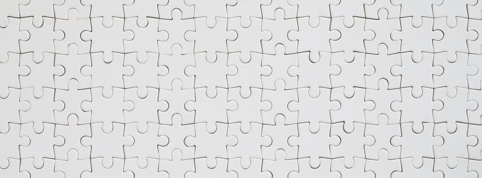 Close up texture of a white jigsaw puzzle in assembled condition. Top view. Many components of a large whole mosaic are united photo