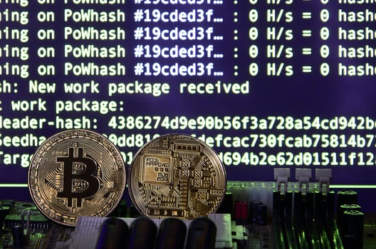 Two bitcoins lies on a videocard surface with background of screen display of cryptocurrency mining by using the GPUs photo