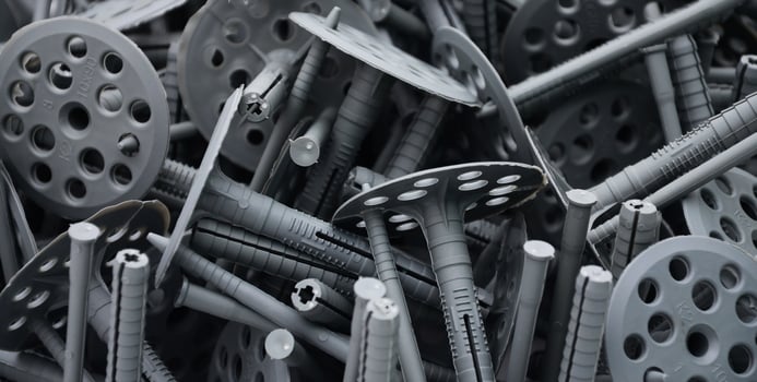 Background pattern of many gray plastic dowels fastening for thermal insulation. A huge pile of fixtures for the installation of expanded polystyrene plates for the insulation of the building walls photo
