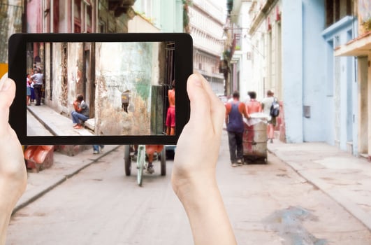 tourist taking photo of old street in Havana