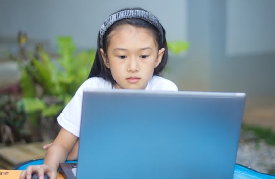 Cute little asian girl using laptop photo