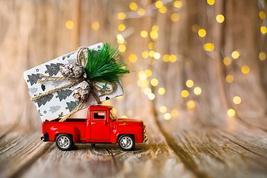 miniature car on wooden background with christmas light, holiday gift. photo