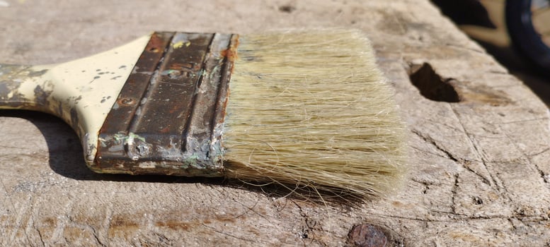 old brush with shabby bristles on long wood photo