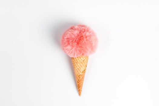 Coral fur ball in waffle cone on white background photo