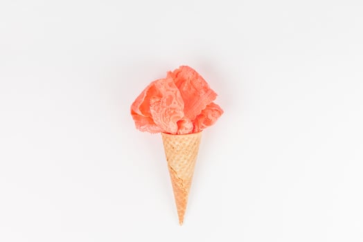 Coral lingerie in waffle cone on white background photo