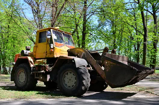 The city improvement team removes the fallen leaves in the park with an excavator and a truck. Regular seasonal work on improving the public places for recreation photo