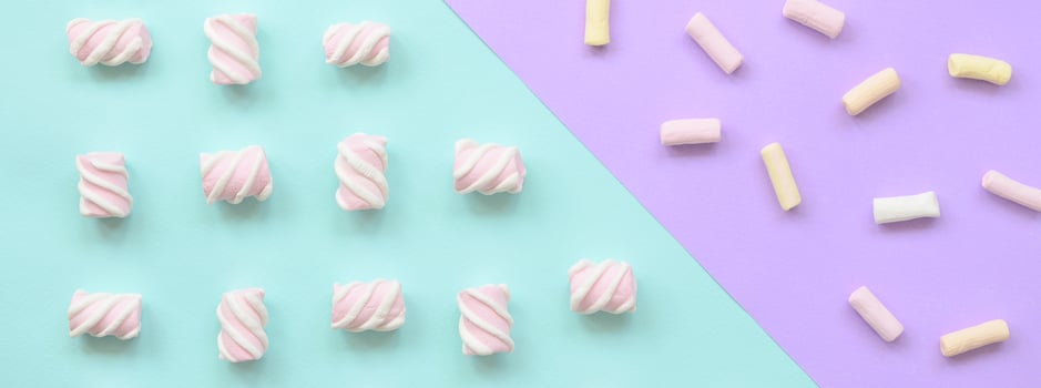 Colorful marshmallow laid out on violet and blue paper background. pastel creative textured pattern. minimal photo