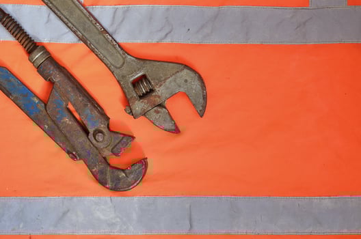 Adjustable and pipe wrenches against the background of an orange photo