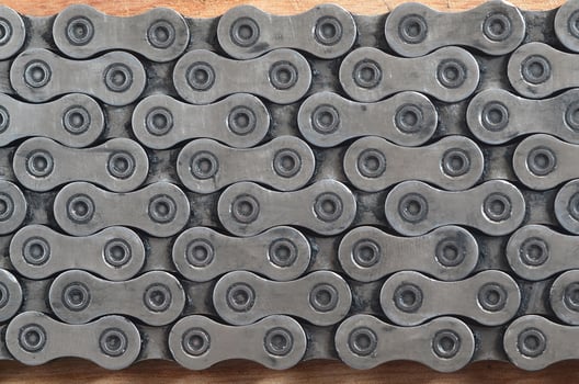 Dirty and oily chain from a mountain bike lying on a wooden table in a bicycle shop photo