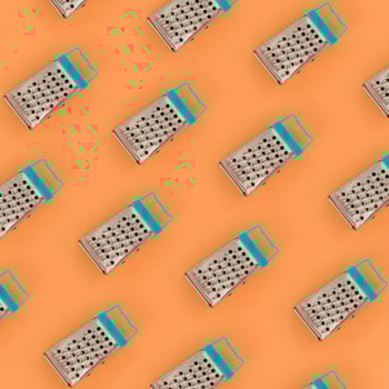Small stainless steel graters lies on a pastel colored paper. Kitchen accessories. Tools for cooking. Flat lay top view photo