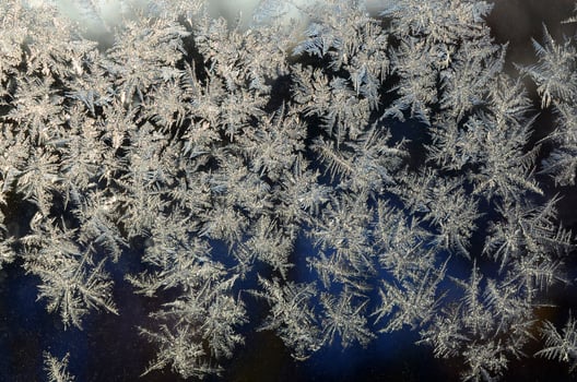 Snowflakes frost rime macro on window glass pane photo