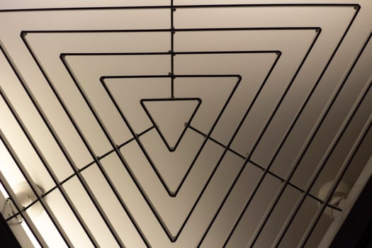 Triangular lamp in interior. Design of lighting device. Lamp on ceiling. photo