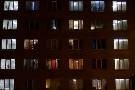 Windows in house at night. Light from windows of apartments. Building is in dark. Night City. photo