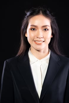 Half body 20s Asian Woman wear formal suit blazer shirt dress. Black long straight hair female feel happy smile fashion vintage poses profile look at camera over black background isolated photo