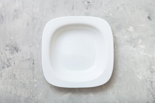 above view square white deep plate on concrete photo