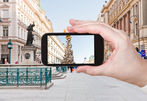 tourist taking photo of plague column in Vienna