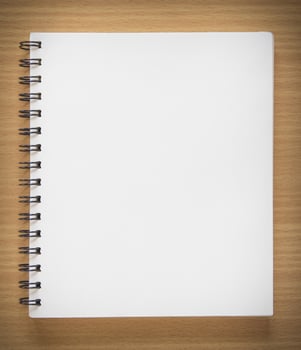 blank spiral notebook on wood background photo