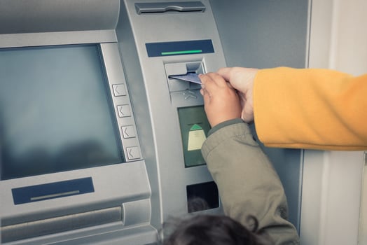 Close up of mother and daughter withdrawing money from ATM. photo