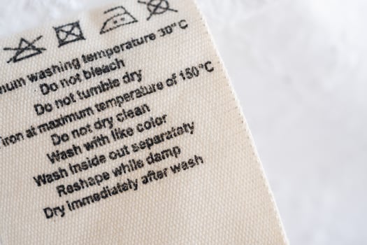 laundry care washing instructions clothes label on fabric texture background photo