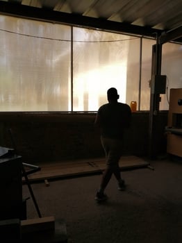 two men carrying a wooden board, working in a carpentry shop. photo