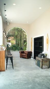 cozy space, with antique furniture, at the back an arched window and greenery behind, old typewriter photo