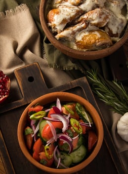 A vertical shot of a chicken covered in creamy sauce and eggplant salad photo