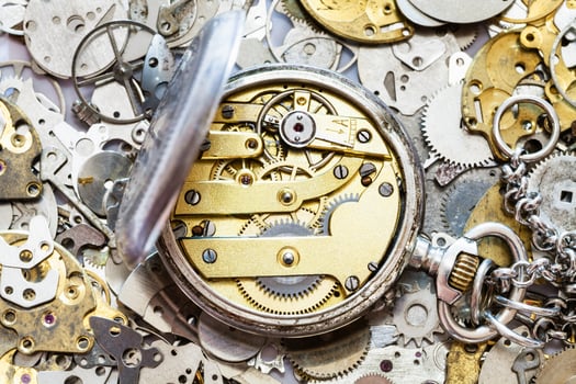 open vintage pocket watch on heap of spare parts photo