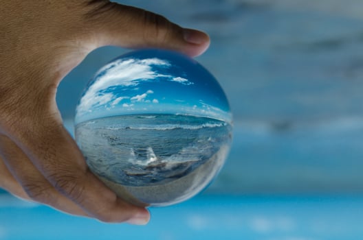 Beautiful Blue sky at oceanside in clear crystal glass ball. photo