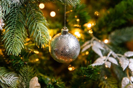 Classic Christmas decorated New year tree. Christmas tree with wite and silver decorations, ornaments toy and ball. Modern classical style interior design apartment. Christmas eve at home. photo
