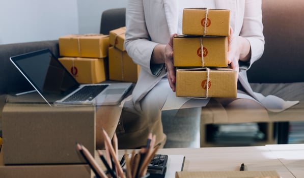 Startup SME small business entrepreneur of freelance Asian woman using a laptop with box Cheerful success Asian woman her hand lifts up online marketing packaging box and delivery SME idea concept photo