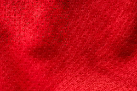 Red fabric sport clothing football jersey with air mesh texture background photo
