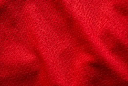 Red fabric sport clothing football jersey with air mesh texture background photo