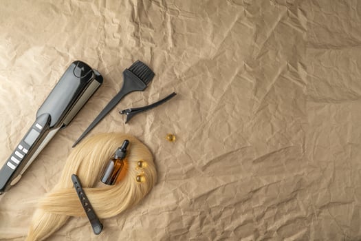 A hair care serum or essential oil and instruments for hair treatment lying on a craft paper photo