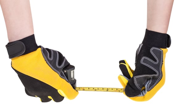 worker hands in safety gloves with measuring tape photo