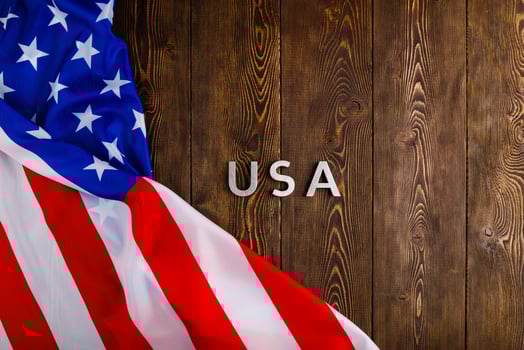 the word USA laid with silver metal letters on wooden board surface with crumpled flag of United States of America photo