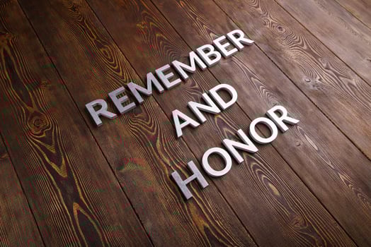 words remember and honor laid with silver metal letters on wooden background photo