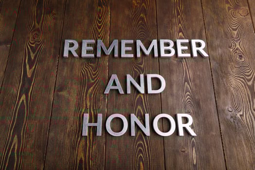 words remember and honor laid with silver metal letters on wooden background photo